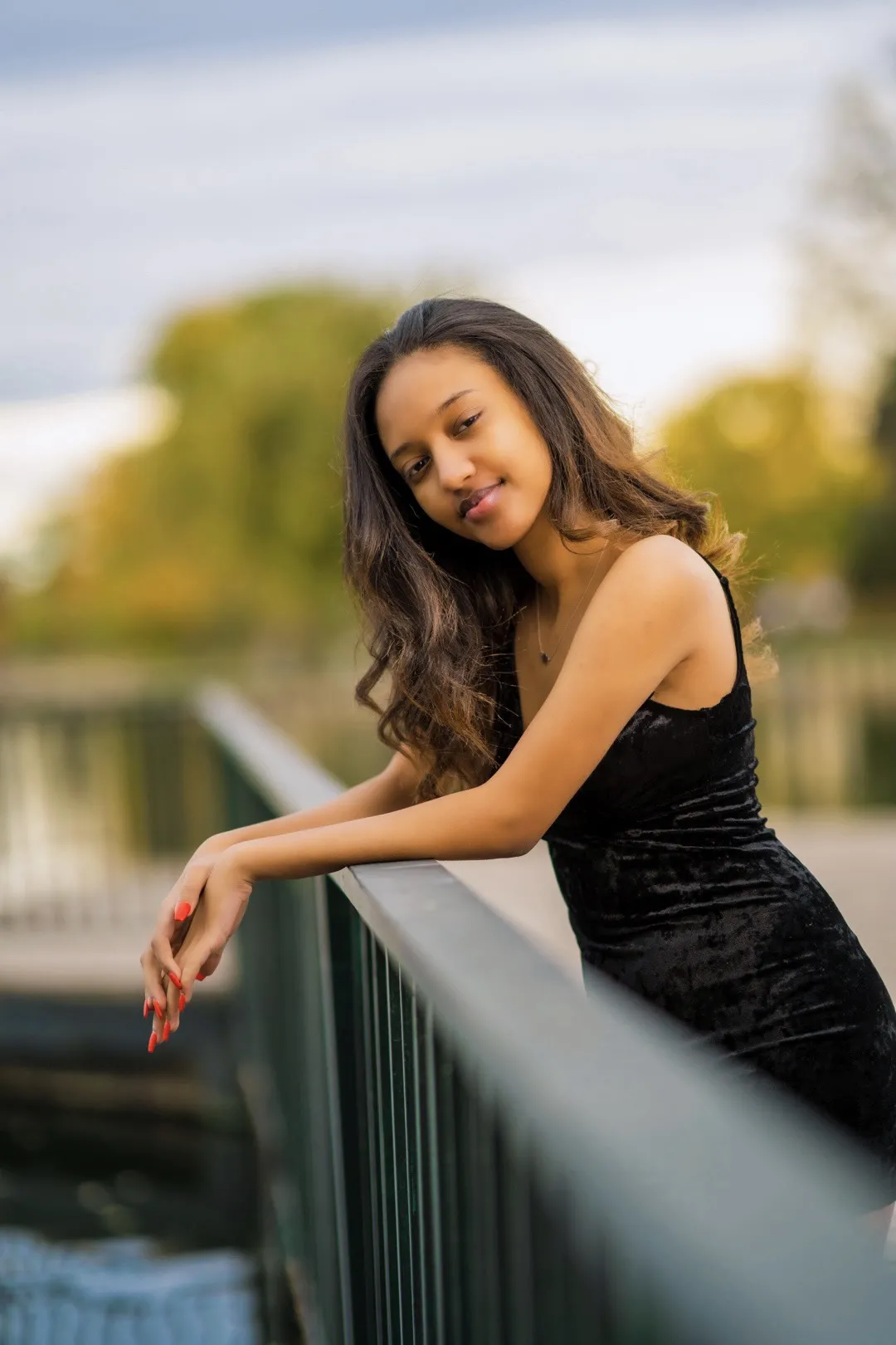 Picture woman standing in black dress over railing