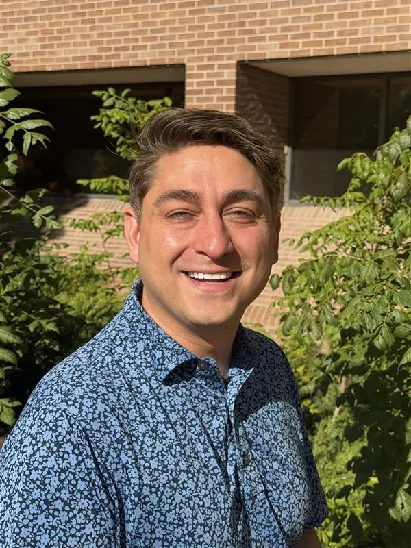 Headshot of David Schieler in a blue shirt. He has brown hair and blue eyes with tan white skin.