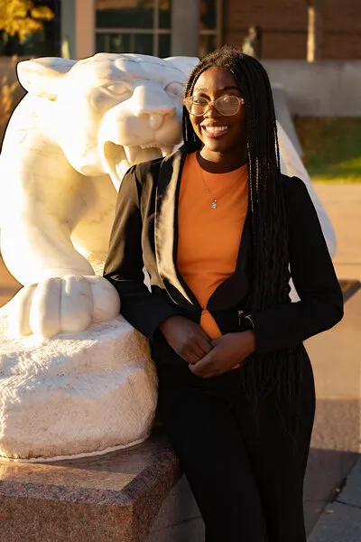 Woman with black hair and black vest standing next to mountain lion