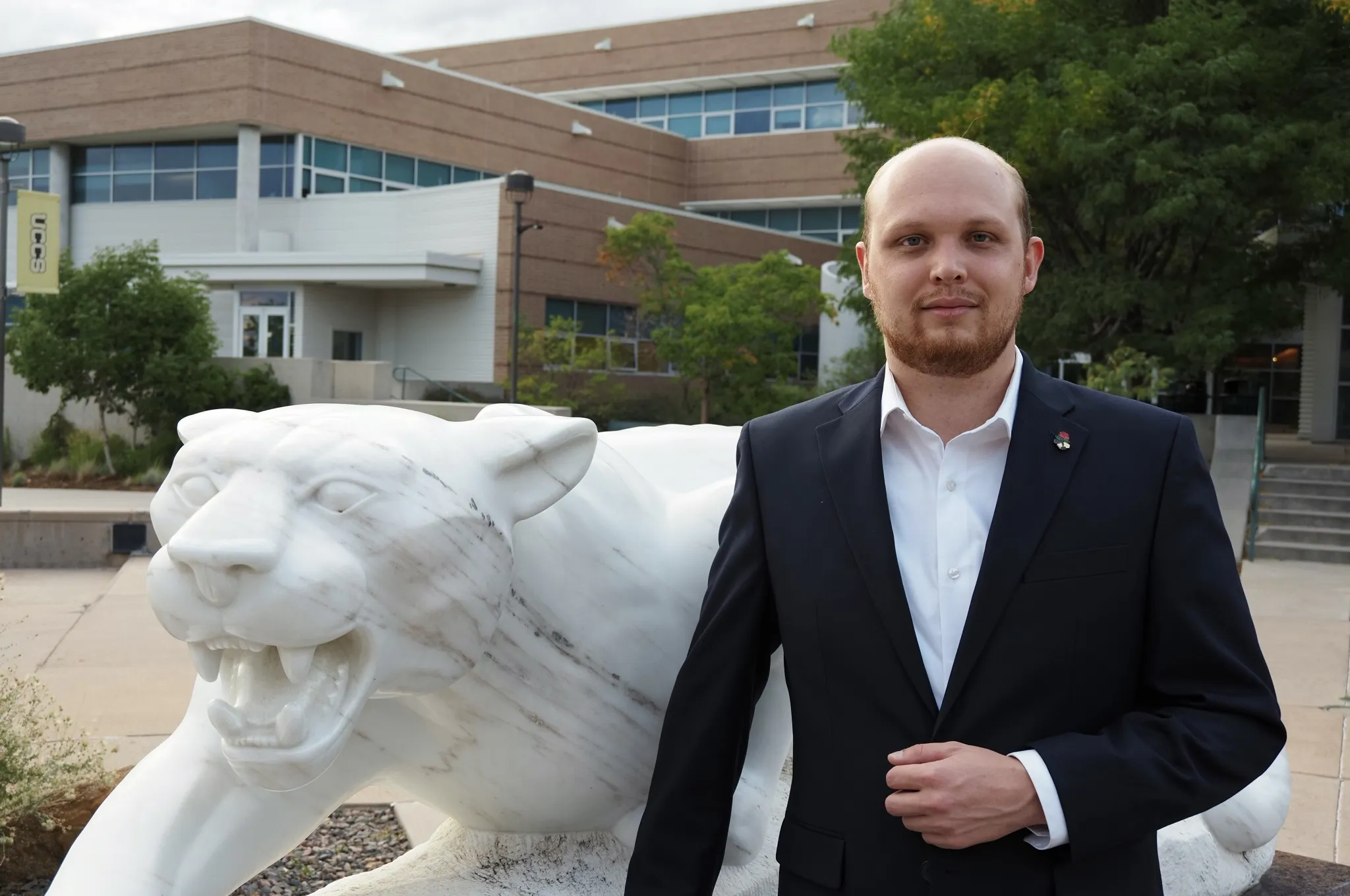 Photo of Logan Smith posing next to a Mountain Lion Statue