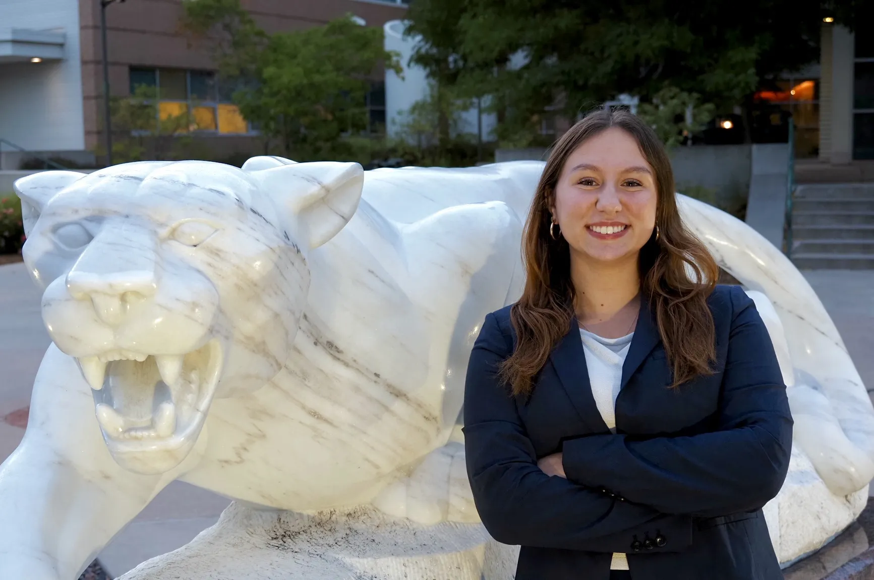 Photo of Keira McWilliams posing next to a mountain lion statue