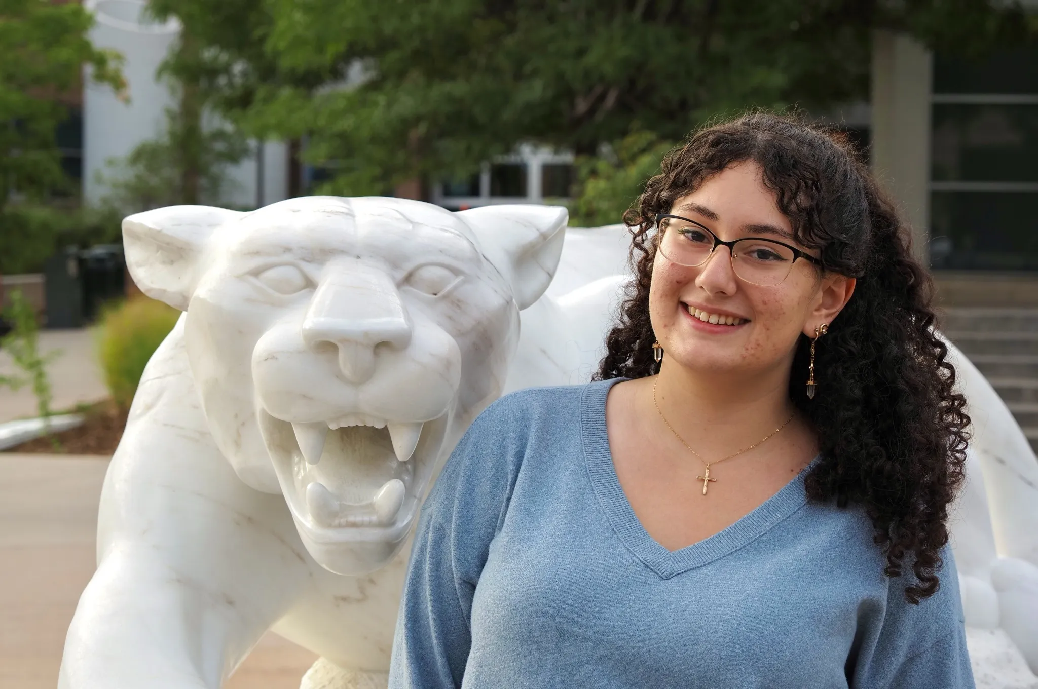 Photo of Maraya Tejeda-Rodriguez posing next to a mountain lion statue