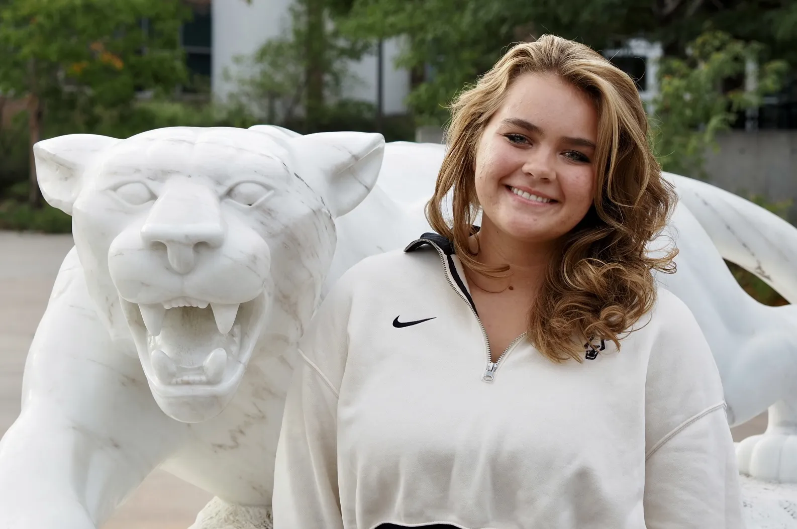 Photo of Sofia Voicu posing next to a mountain lion statue